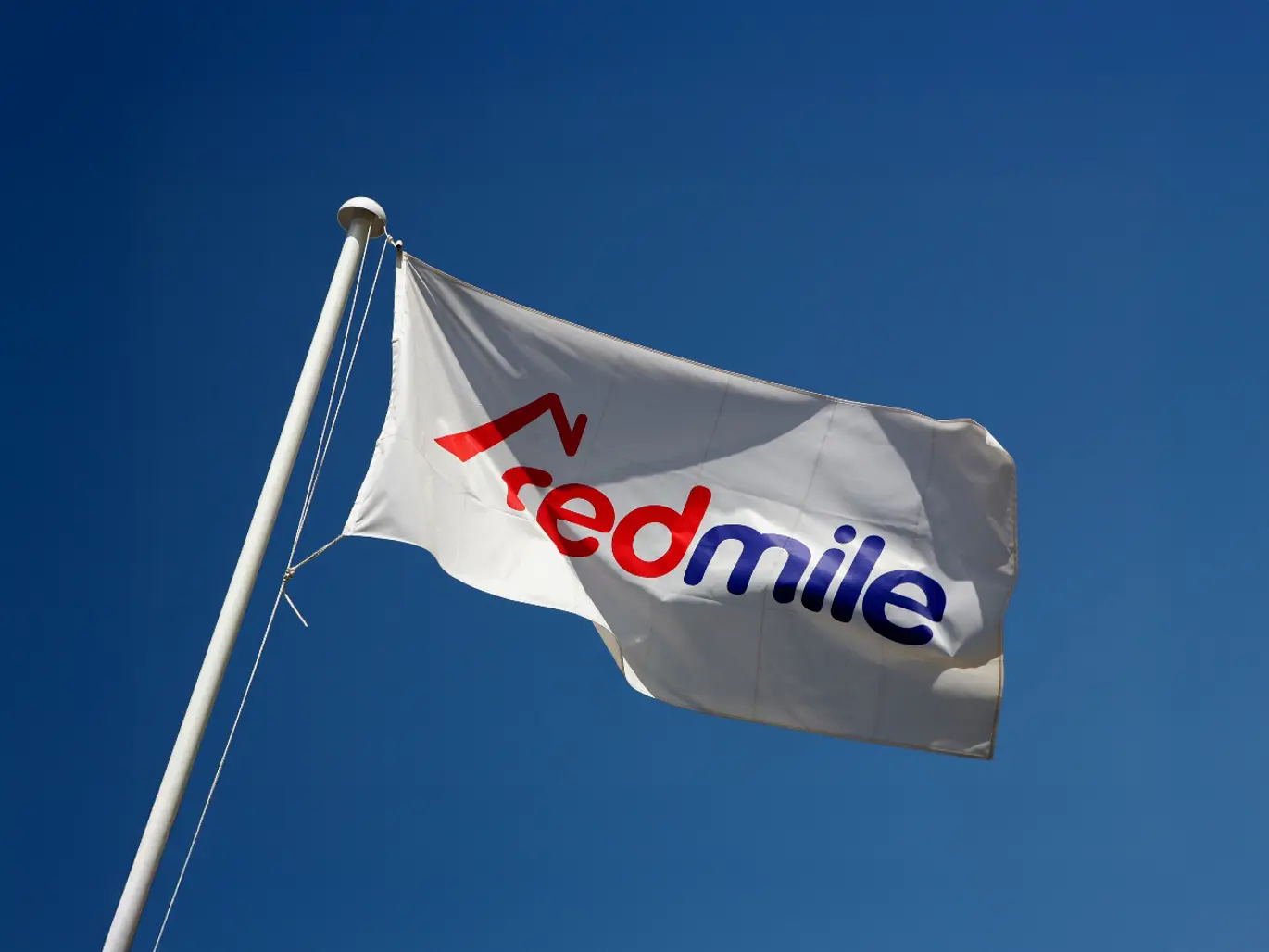 Exterior Flag and Flagpole with Redmile Homes Flag billowing in wind
